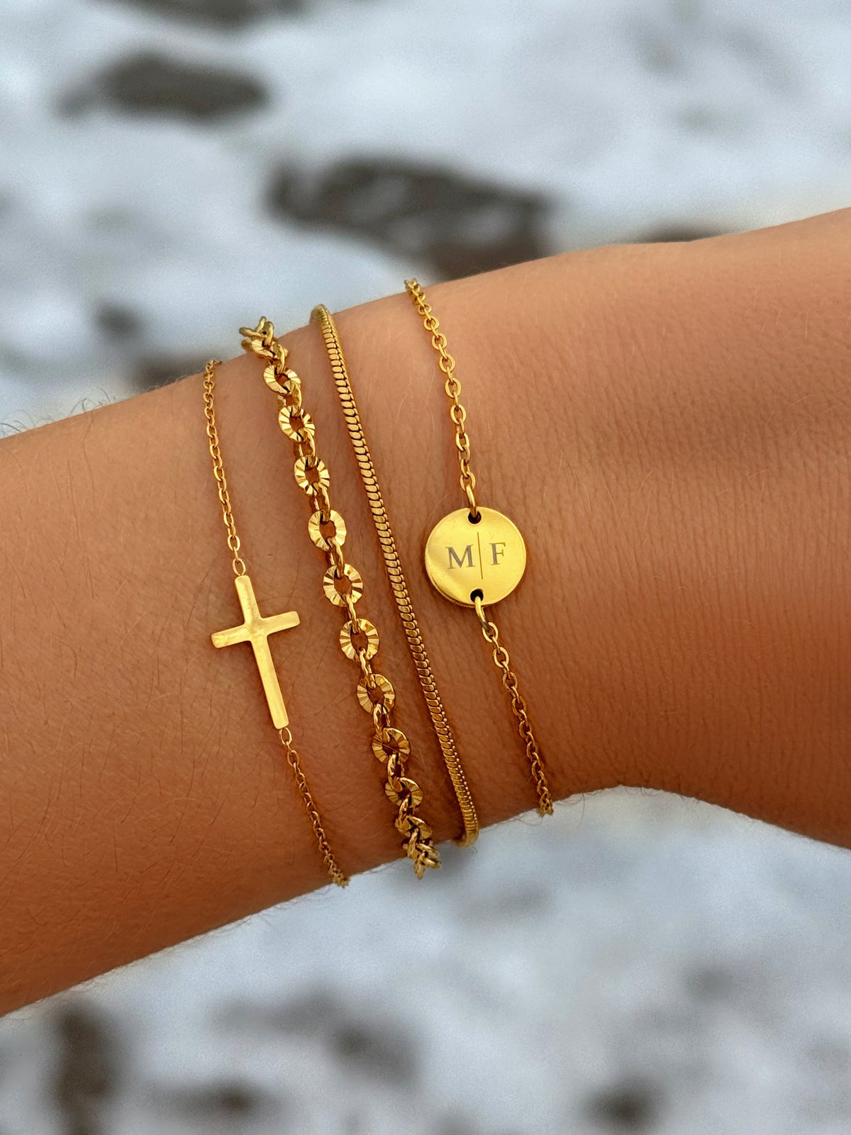 Kruisarmband in goud- en zilverkleur